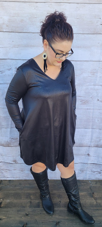 This dress is a shiny metallic faux leather. "Nobody's Angel" dress in knee length that features long sleeves, pockets, v-neck and v-back. Imagine yourself going out friends, dancing, or shopping the town. You will definitely turn heads. Enjoy your self in this must have black dress. Go ahead and try something new! Maybe learn to line dance!