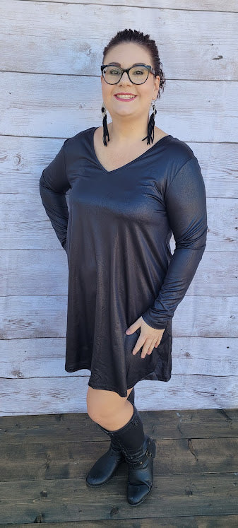 This dress is a shiny metallic faux leather. "Nobody's Angel" dress in knee length that features long sleeves, pockets, v-neck and v-back. Imagine yourself going out friends, dancing, or shopping the town. You will definitely turn heads. Enjoy your self in this must have black dress. Go ahead and try something new! Maybe learn to line dance!