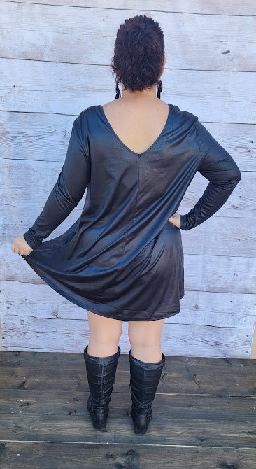 This dress is a shiny metallic faux leather. "Nobody's Angel" dress in knee length that features long sleeves, pockets, v-neck and v-back. Imagine yourself going out friends, dancing, or shopping the town. You will definitely turn heads. Enjoy your self in this must have black dress. Go ahead and try something new! Maybe learn to line dance!