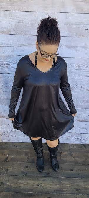 This dress is a shiny metallic faux leather. "Nobody's Angel" dress in knee length that features long sleeves, pockets, v-neck and v-back. Imagine yourself going out friends, dancing, or shopping the town. You will definitely turn heads. Enjoy your self in this must have black dress. Go ahead and try something new! Maybe learn to line dance!