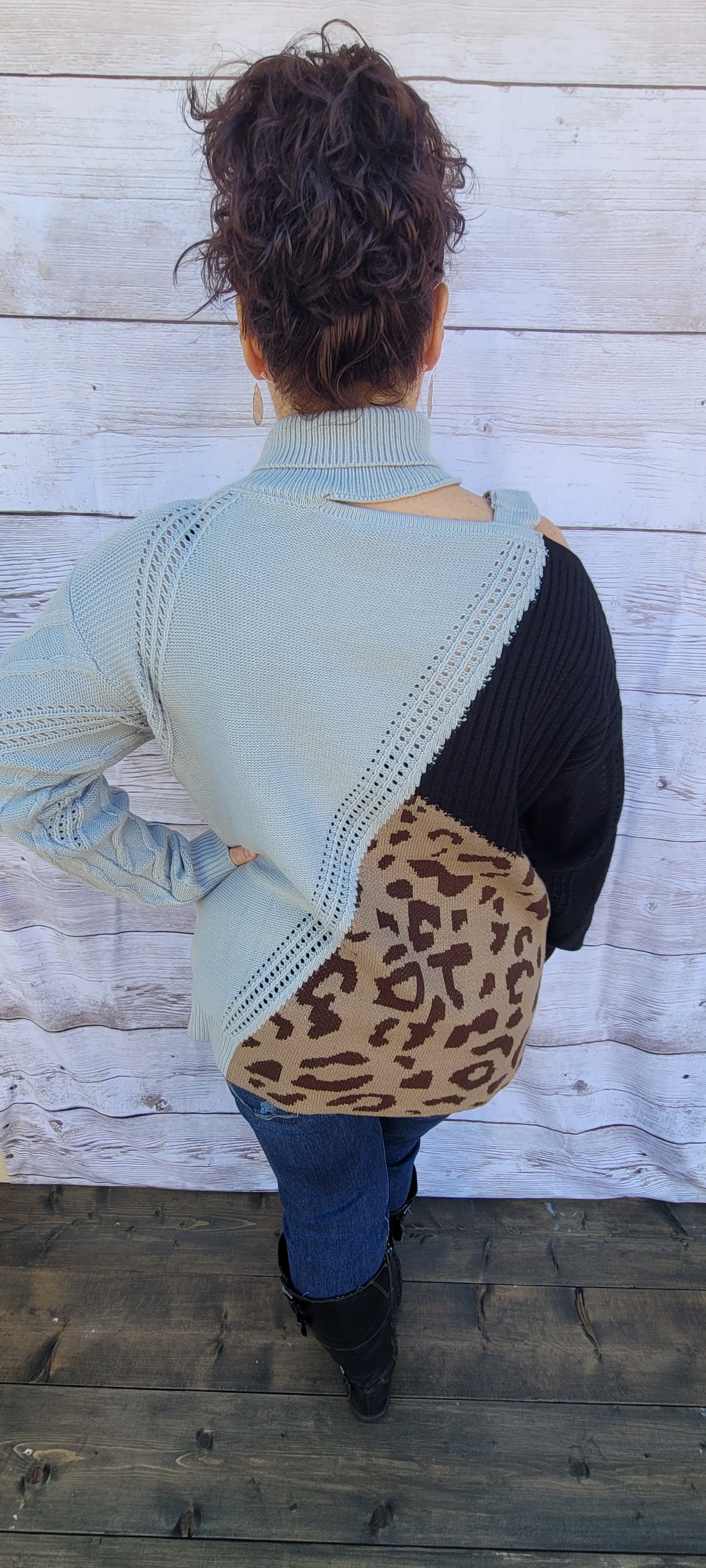 This is a comfy unique block sweater. featuring a gray, black and leopard color block turtleneck with one cut-out shoulder and a non-functioning buckle.  It has an added design on the front that you will not find anywhere else.  You will definitely stand out with this unique sweater.  Wear this with your favorite jeans or skirt.  This would be the perfect sweater for the office, everyday wear, or hanging out with your family and friends. Sizes small through 3XL.