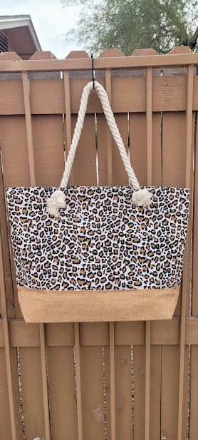 This leopard print tote features a cream color braided handle with a zipper top.&nbsp; The material is polyester. The inside has a lining with a pocket for all of the small stuff that you do not want to get lost.&nbsp; The outside bottom has a burlap color fabric. This tote is very versatile.&nbsp; Imagine yourself heading to the beach, going shopping, or heading to the local market, you will get a lot of use out of this super cute tote.
