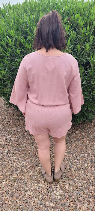 This dusty blush linen blend romper features a scallop hemmed,  elastic waistband, scallop edge around shorts, scallop neckline, with snap closure,  3/4  bell sleeves, and a drawstring with pockets. Get ready for a road trip.  See where this very cute romper takes you.  If vacation is in your future, then this is a must have.  You will feel comfortable and look oh so cute! Sizes small through large.
