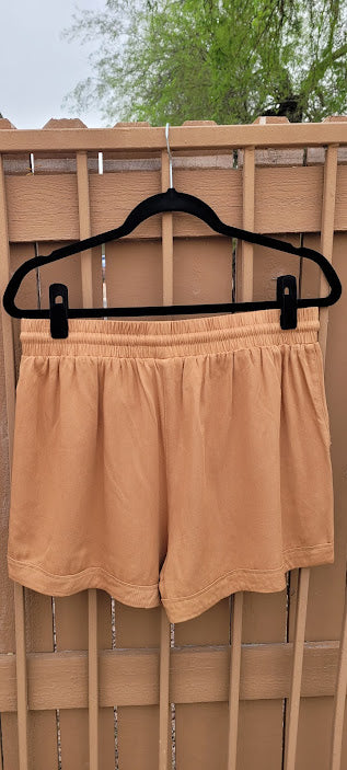 Rock the desert in these very cute camel color shorts.  These shorts feature a cuffed hem, pockets, and an elastic waist with a draw string.  These cute shorts can be dressed up, or casual. You can wear these to the office, heading out on the town, to a party, or hanging out with the girls.  You will feel comfortable no matter what you decide to wear this to.  Sizes small through large.