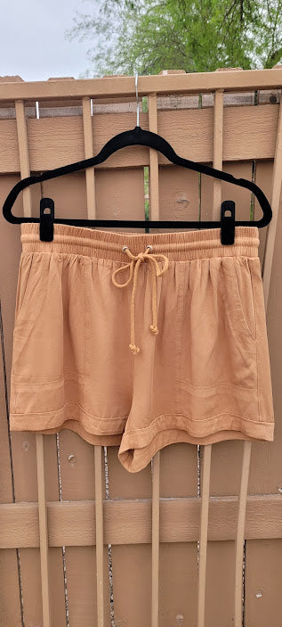 Rock the desert in these very cute camel color shorts.  These shorts feature a cuffed hem, pockets, and an elastic waist with a draw string.  These cute shorts can be dressed up, or casual. You can wear these to the office, heading out on the town, to a party, or hanging out with the girls.  You will feel comfortable no matter what you decide to wear this to.  Sizes small through large.