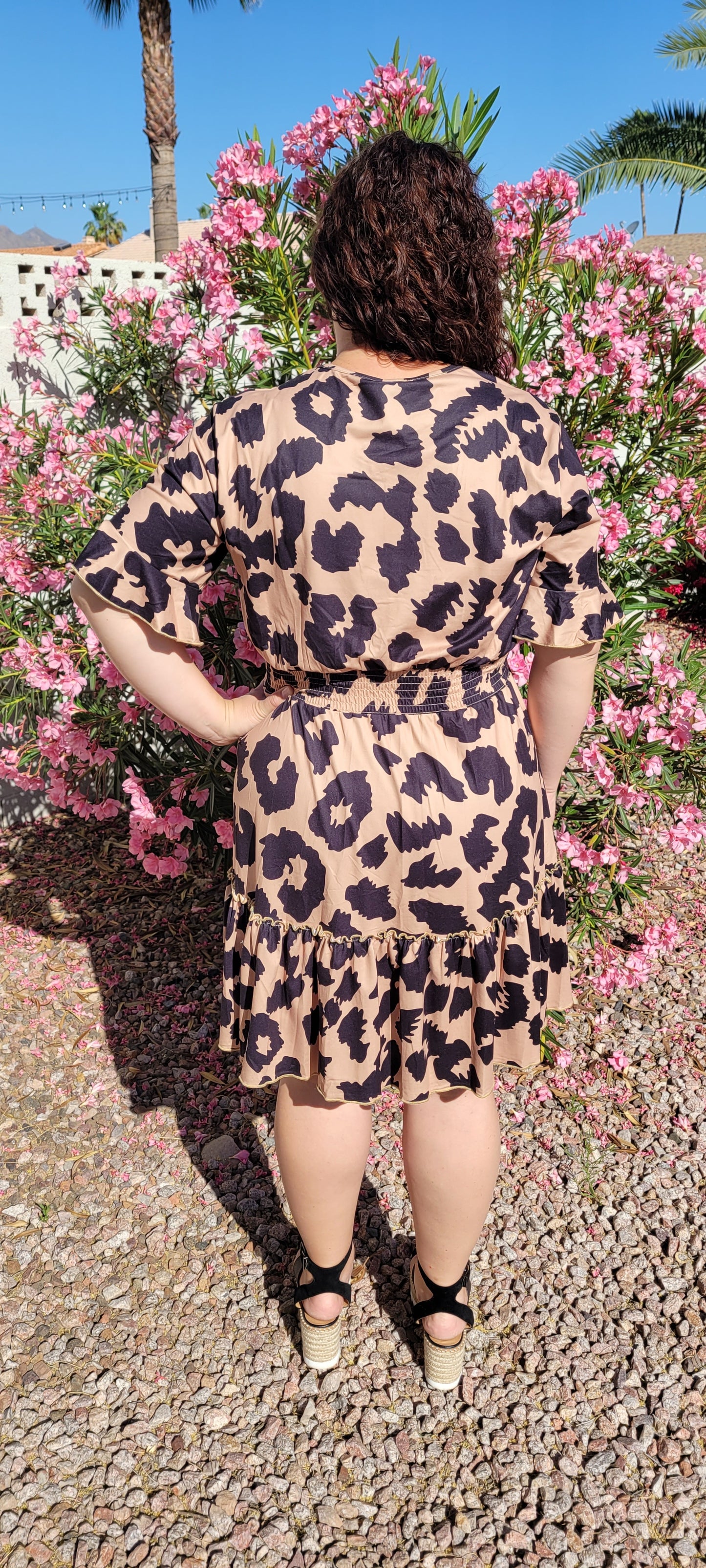 “The Wild Side” is a camel and black colored dress. This dress features a buttery soft animal print, v-neck, elastic cinched waistband, short bell sleeves with ruffles, and ruffle hemline. It sits above the knee. This dress is just as cozy as pajamas! Sizes small through large