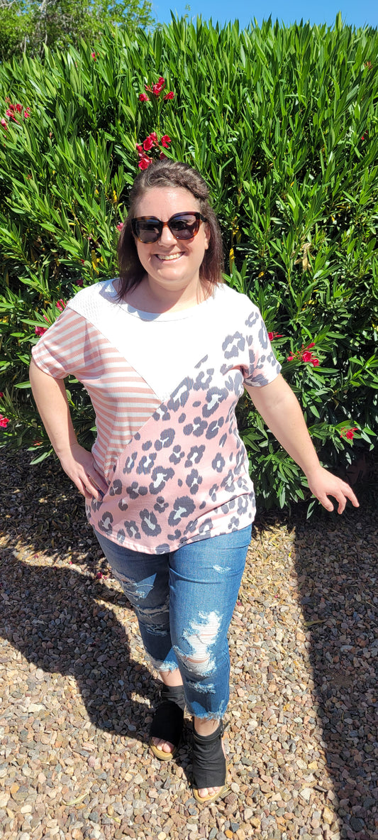 “Spoken From The Heart” is a comfy and casual t-shirt! This short sleeve shirt features pattern blocking, leopard print (pink, gray, white), stripes (coral, white) and solid waffle (white). This shirt has three different materials and textures, and a rounded neckline. Pair with your favorite pair of denim jeans, shorts, or skirt. Sizes small through large.