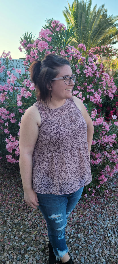 Fancy & Free is a A-line, leopard print, tiered top is sleeveless, flowy and sheer. It features a key hole back with button closure, and has a rounded neckline.  This top is light pink with brown leopard print. It is great for vacation, an evening out, casual event, a day out on the town with your friends, or just because. Sizes small through large.