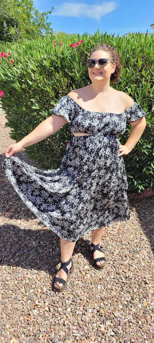 “Vacay Mode” is a black and white floral dress. This dress features peek-a-boo cutouts, open back with bow tie, tiered hemline, midi length, elastic neckline, puff sleeves, and waistline. This is a woven, non-stretch fabric, unlined, non-sheer, and lightweight. You can wear this dress on or off your shoulders. Sizes small, medium and large
