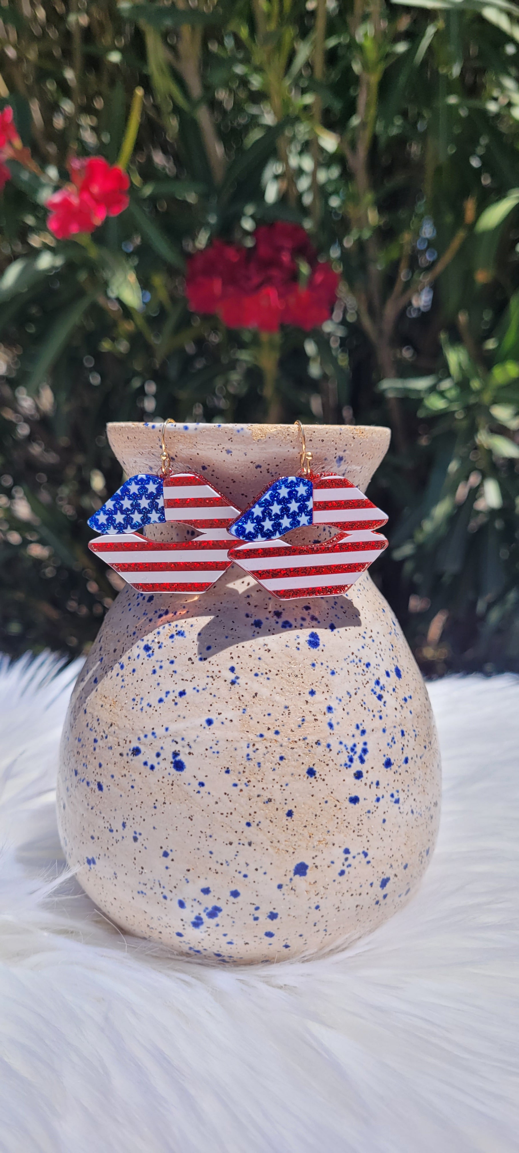 Lip shape American flag print Blue and red glitter Epoxy material Light weight Brushed gold fish hook dangle earrings Rubber earring back Whether you want to be on the wild side or classy this earring set it will add a fun touch to your outfit