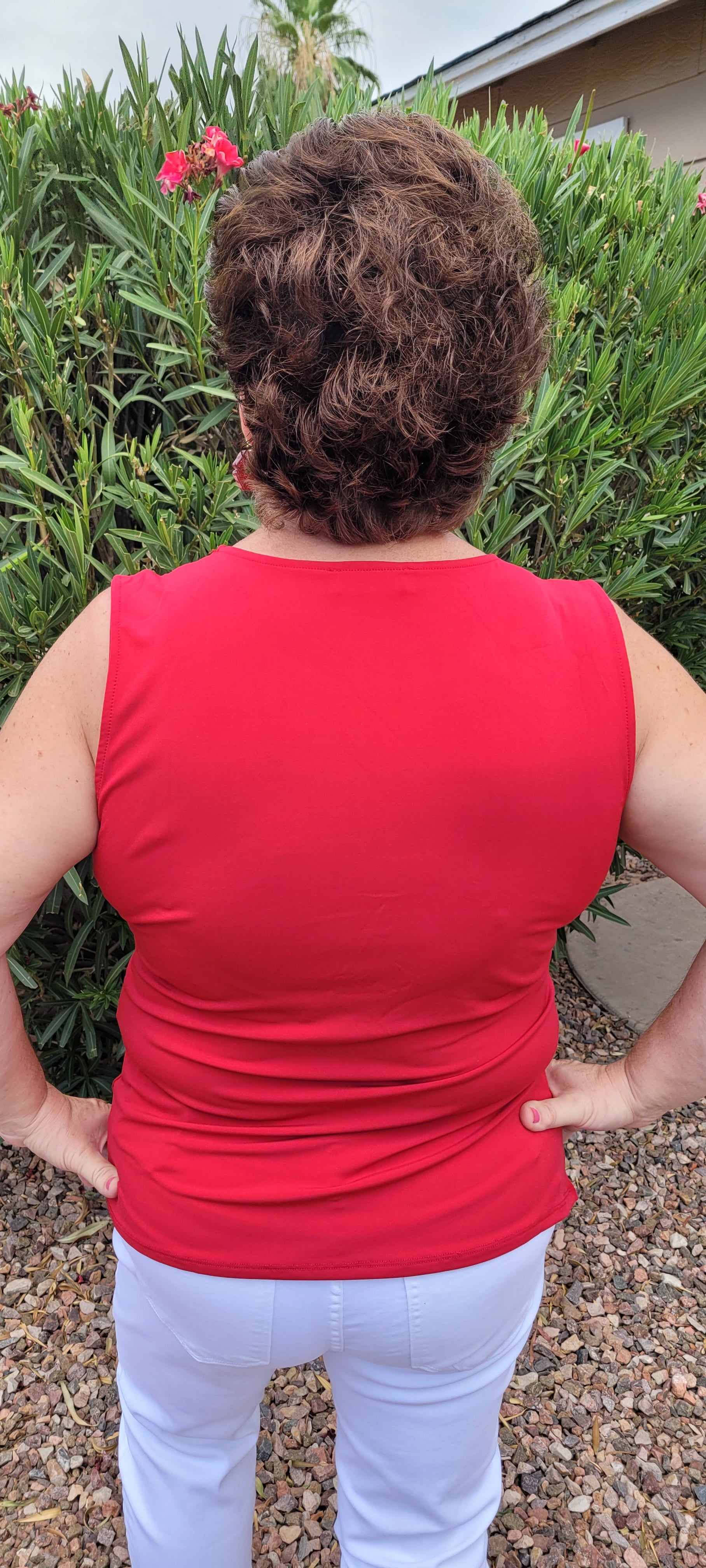 This is a perfect basic staple piece! It is a great piece for layering or great all by itself! This is a sleeveless round neck top, with a knot in front which gives it a gathered layered look, and straight line hem. The color is red. Pair with your favorite pair of denim jeans, shorts, or skirt. Sizes small to X-large