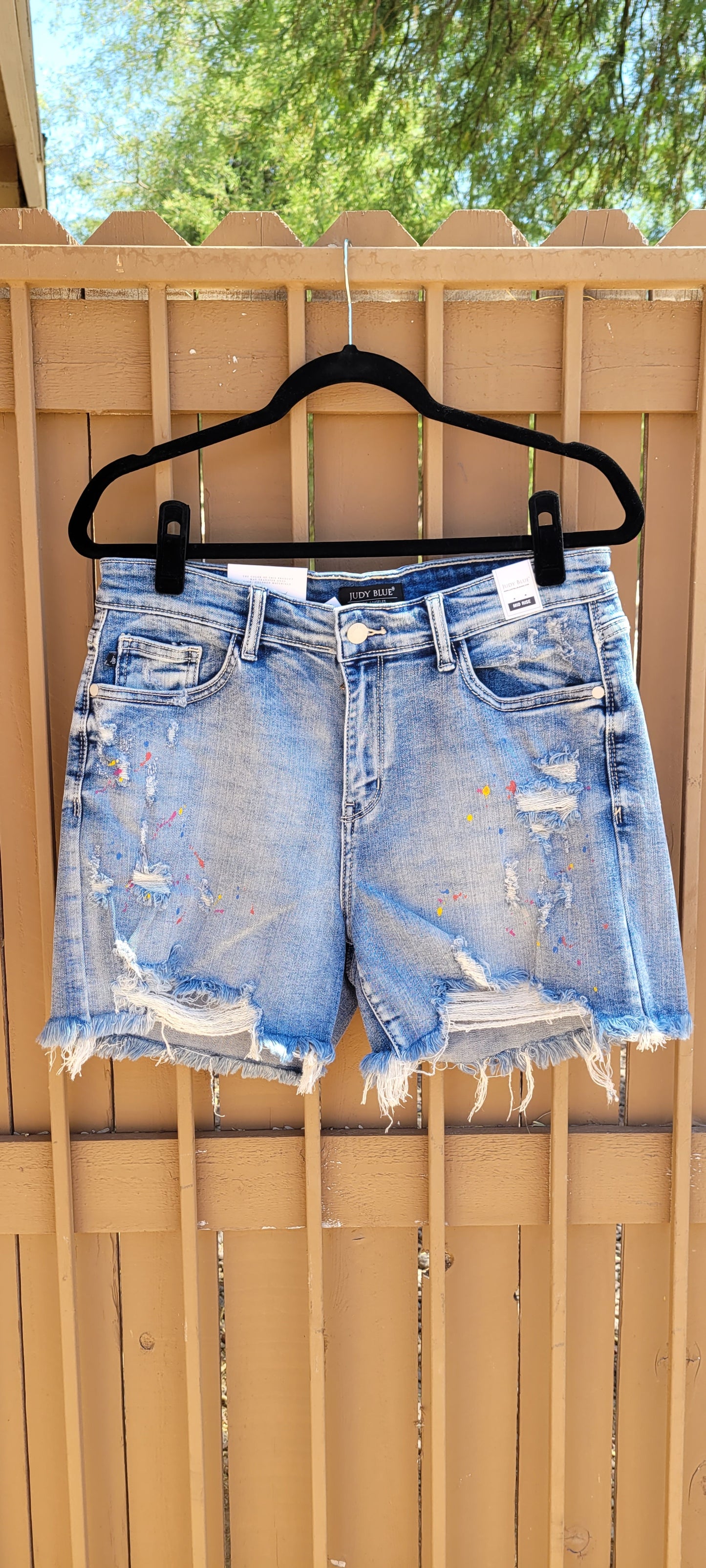 These are mid rise, light wash, distressed shorts featuring paint splatter (blue, yellow, pink), a frayed and distressed hemline, functional pockets in the front and back.  These shorts are stretchy for comfort. Sizes small through x-large.
