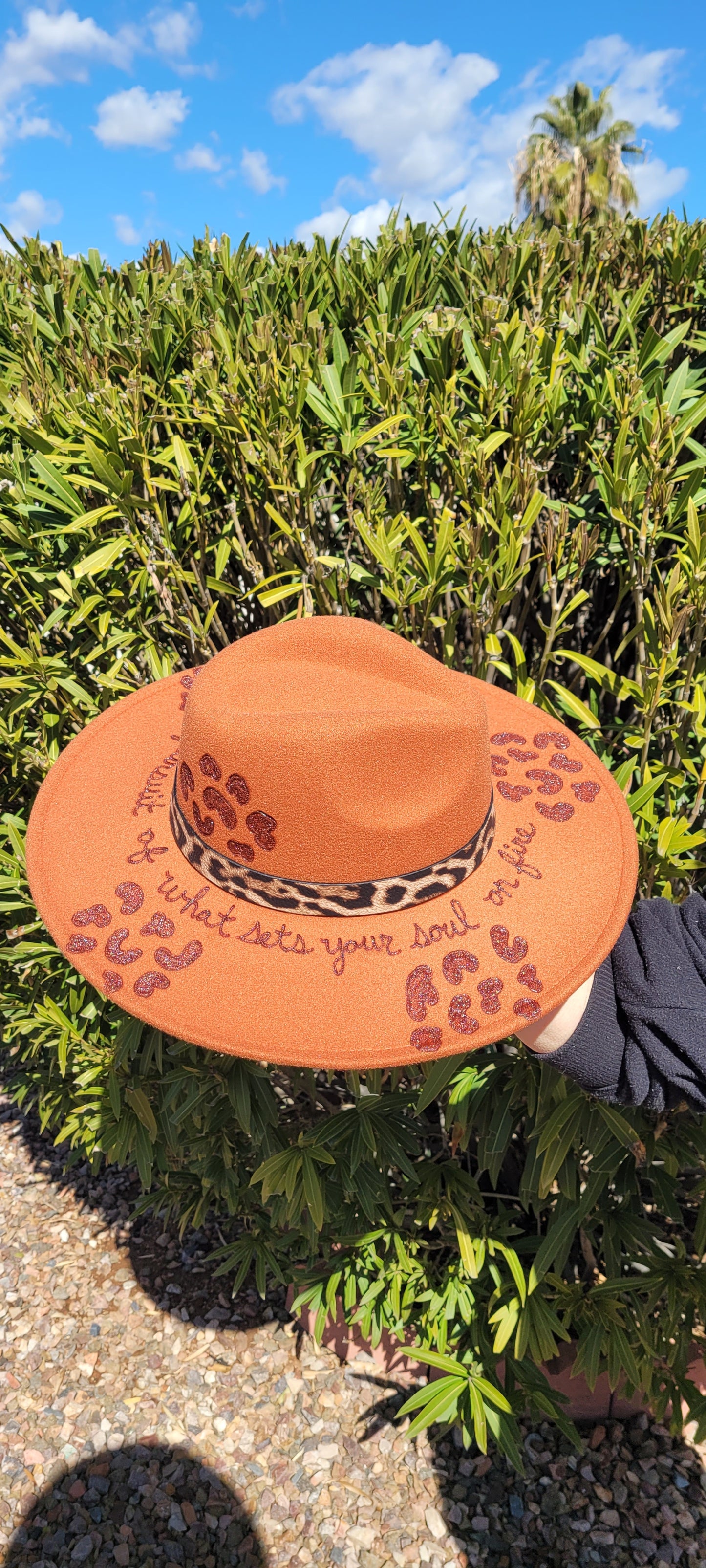 Features brim detailing with leopard print and "be fearless in the pursuit of what sets your soul on fire" engraving Leopard band around brim Felt hat Flat brim 100% polyester Ribbon drawstring for hat size adjustment Head Circumference: 24" Crown Height: 5" Brim Length: 15.75" Brim Width: 14.5" Branded & numbered inside crown Custom engraved by Kayla