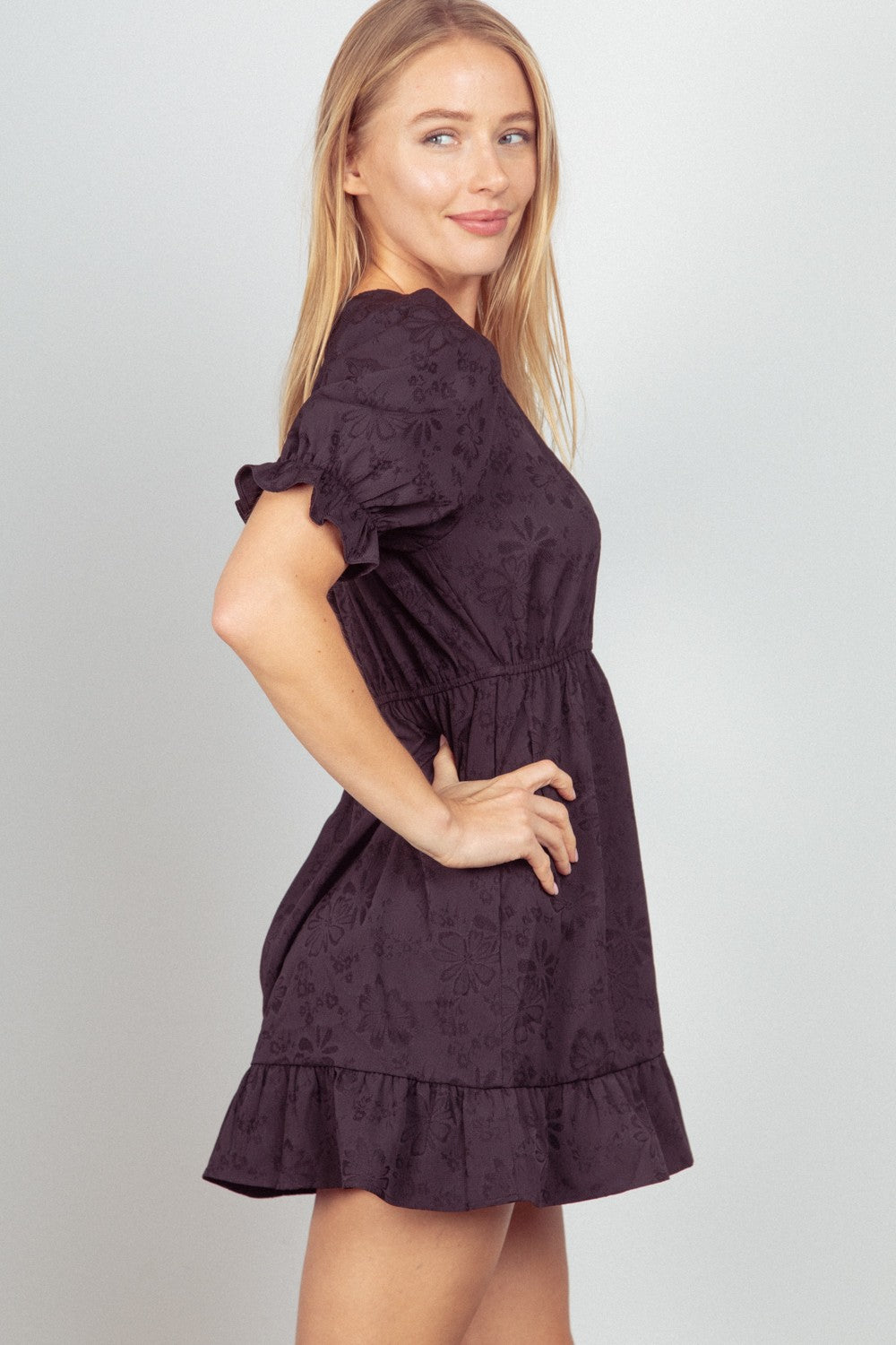 This Floral Textured Woven Ruffled Mini Dress is a charming and feminine choice for any special occasion. The floral textured fabric adds a romantic touch to the sweet ruffled details.  S - L