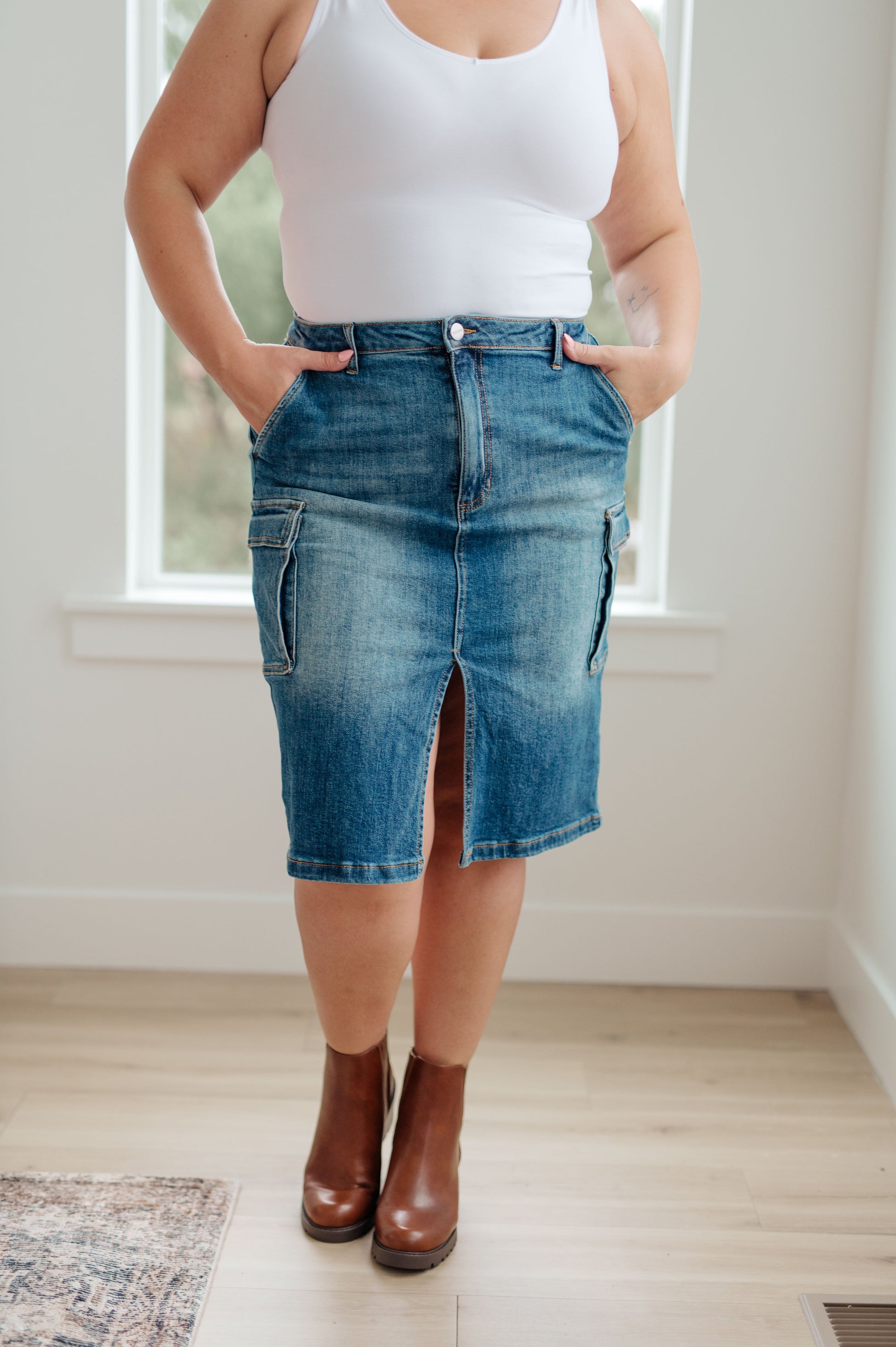 This stylish Always Be There Cargo Denim Skirt is the perfect piece for everyday wear. It's crafted with stretchy medium wash denim for a comfortable fit and extra movement, and features a front slit and cargo pockets for a more dynamic look. Look great and put your most fashionable foot forward! S - 3X