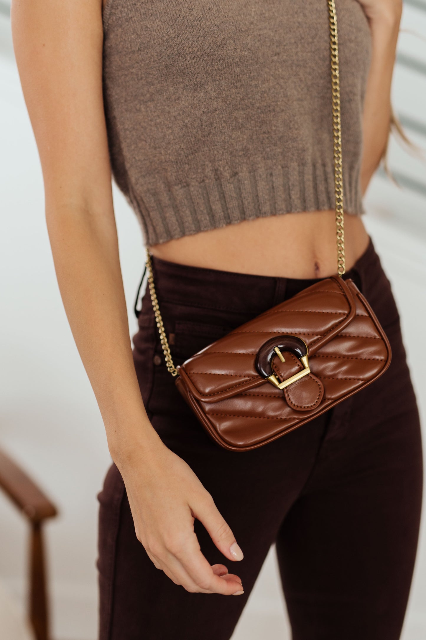 This beautiful Classic Beauty Quilted Clutch is timelessly chic in brown. With its quilted design, decorative wood buckle, magnetic clasp closure, and chain strap, it's the perfect accessory for any elegant event. Upgrade your look with this classic clutch!