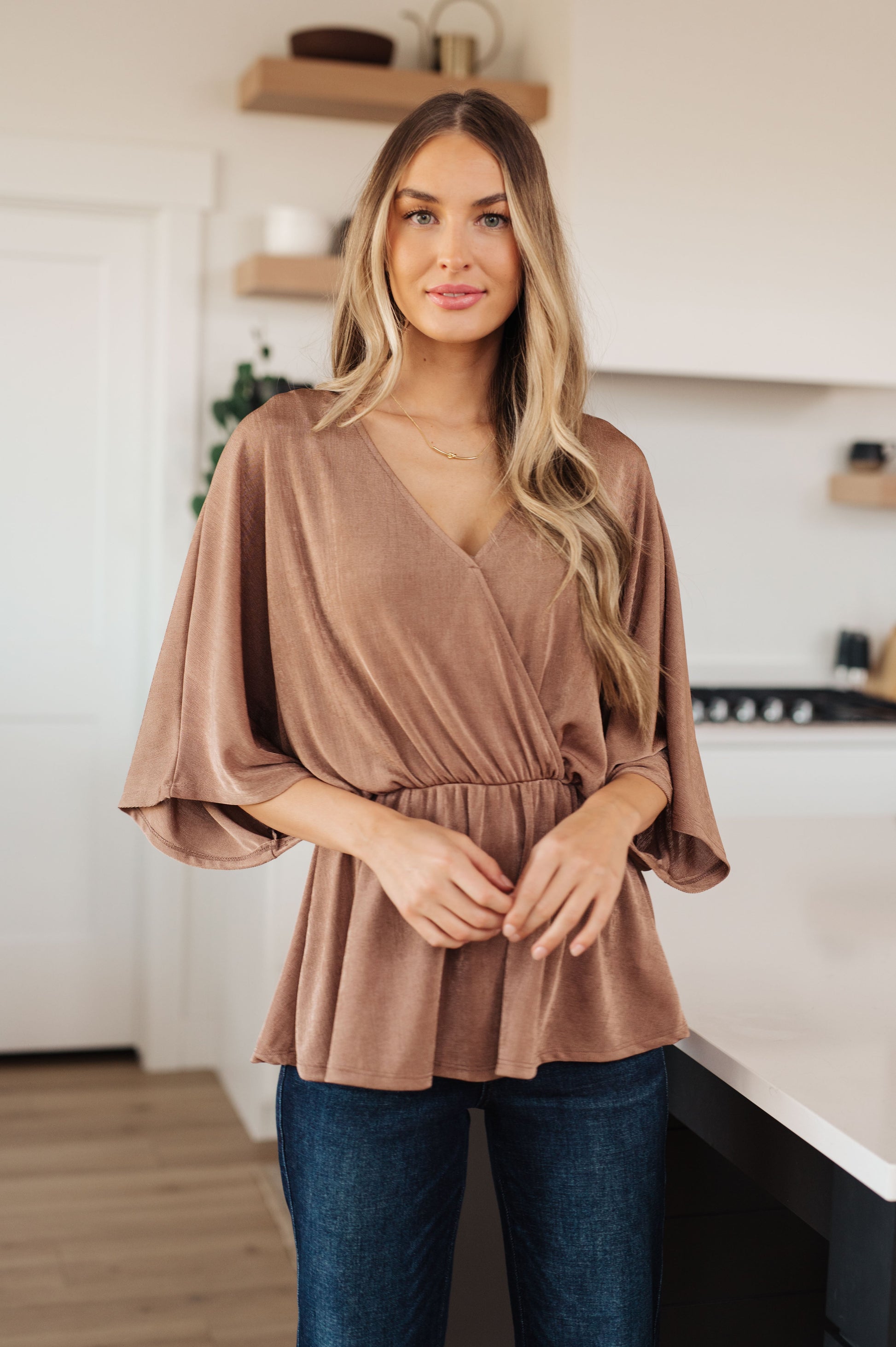 Meet the Dazzlingly Draped V-Neck Blouse! This elevated peplum style is constructed from a gorgeous shimmering bronze fabrication, a surplice front forms the flattering V-neckline. The cased elastic waistband gathers in to create a playful peplum silhouette. Pair with your favorite mini skirt or a pair of denim trousers, this blouse is easy to take from day to night. S - 2X