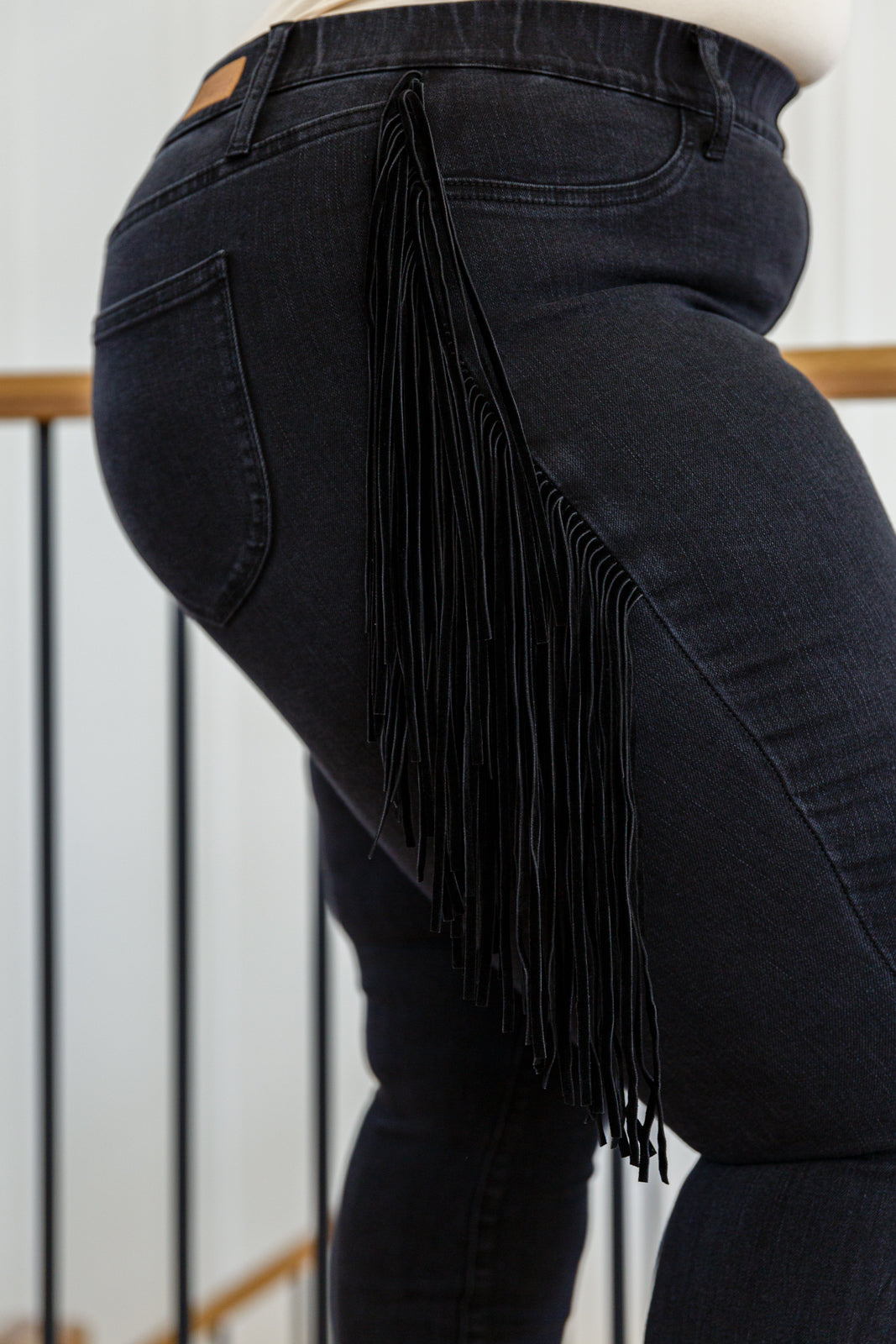 If there's anyone who can totally rock the Hilary Side Fringe Skinny Jegging In Black it's you! These western inspired jeggings feature a mid-rise waist with faux front pockets topping a skinny pant leg. Faux suede fringe decorates either side of these jeans adding a unique and stylish touch. Add cowboy boots and a crop top for a super fun look! 0 - 24W