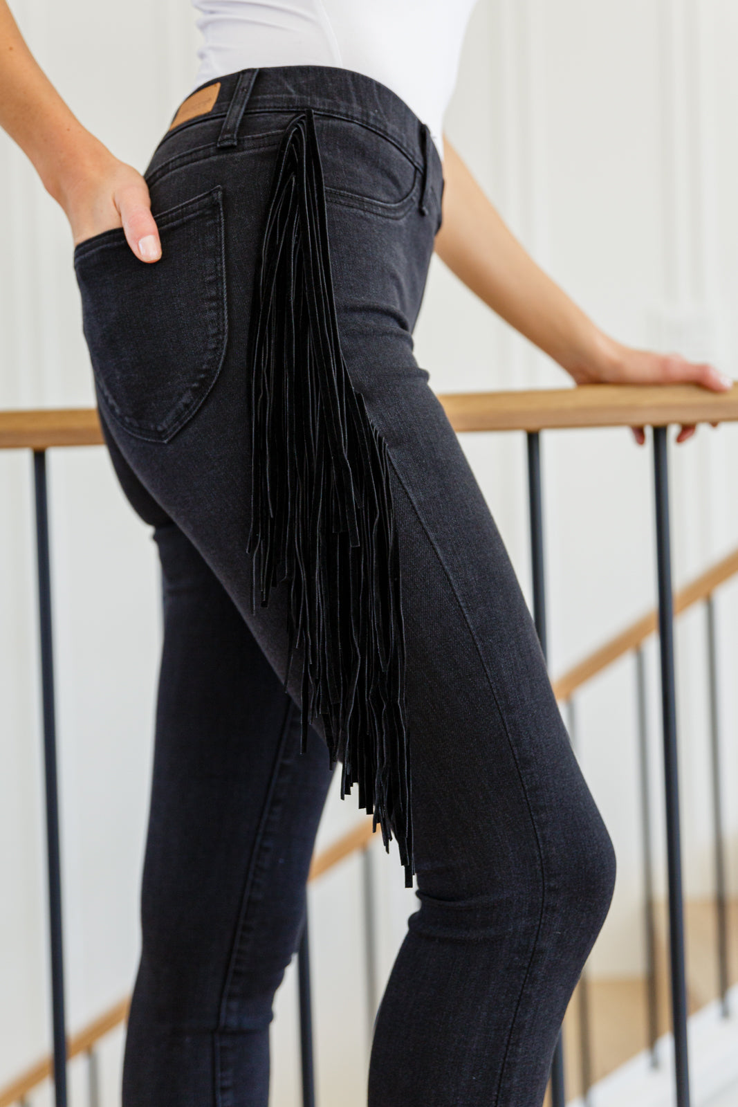 If there's anyone who can totally rock the Hilary Side Fringe Skinny Jegging In Black it's you! These western inspired jeggings feature a mid-rise waist with faux front pockets topping a skinny pant leg. Faux suede fringe decorates either side of these jeans adding a unique and stylish touch. Add cowboy boots and a crop top for a super fun look! 0 - 24W