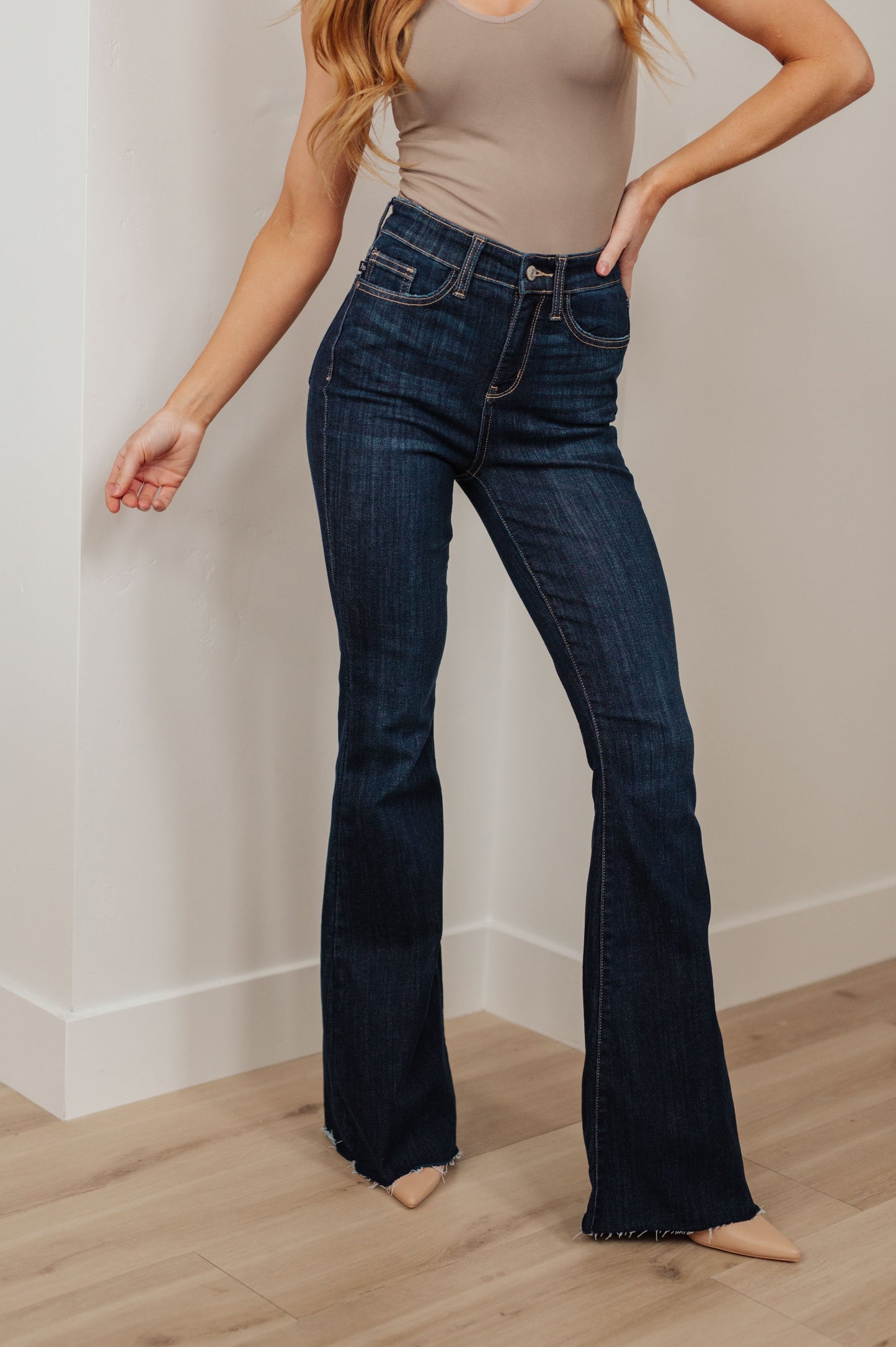 Our Jane High Rise Raw Hem Flare Jeans from Judy Blue are the perfect piece for any wardrobe. The high-rise design offers increased coverage, while the dark wash, classic flared silhouette and raw hem provide a timeless and effortless look. A great addition to any outfit. 0 - 24