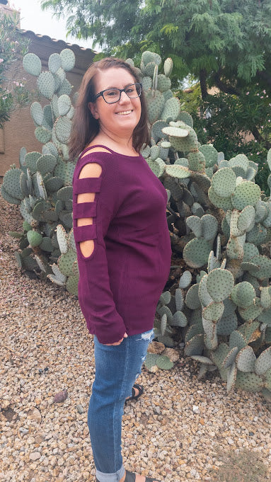 This is a comfy wine ribbed  sweater featuring a boat neckline, with ladder cutout sleeves.   You will definitely stand out with this unique style sweater.  Wear this with your favorite jeans, dress pants or skirt. Sizes small through large. 