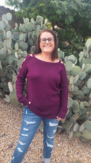 This is a comfy wine ribbed  sweater featuring a boat neckline, with ladder cutout sleeves.   You will definitely stand out with this unique style sweater.  Wear this with your favorite jeans, dress pants or skirt. Sizes small through large. 
