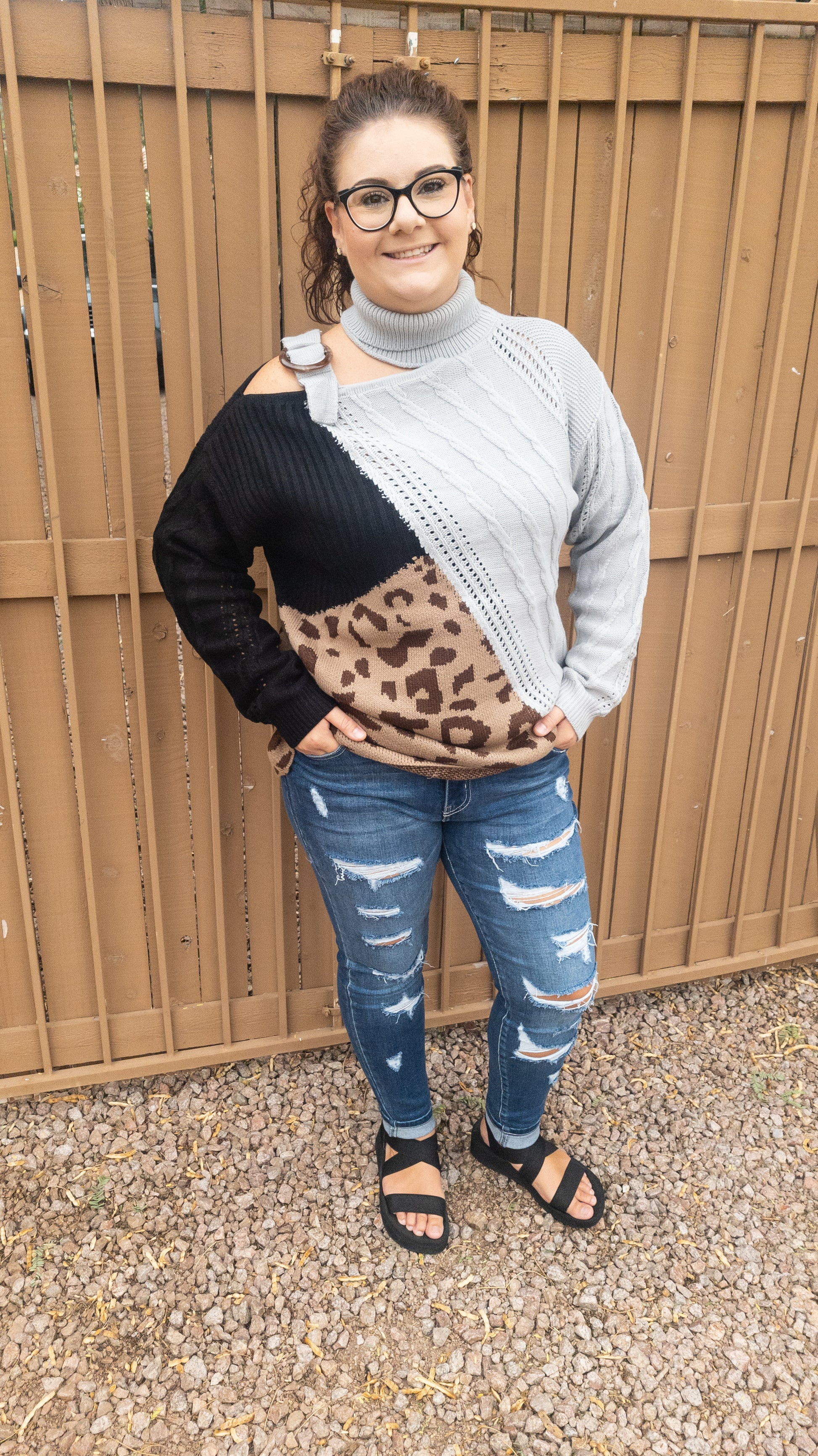 This is a comfy unique block sweater. featuring a gray, black and leopard color block turtleneck with one cut-out shoulder and a non-functioning buckle.  It has an added design on the front that you will not find anywhere else.  You will definitely stand out with this unique sweater.  Wear this with your favorite jeans or skirt.  This would be the perfect sweater for the office, everyday wear, or hanging out with your family and friends. Sizes small through 3XL.