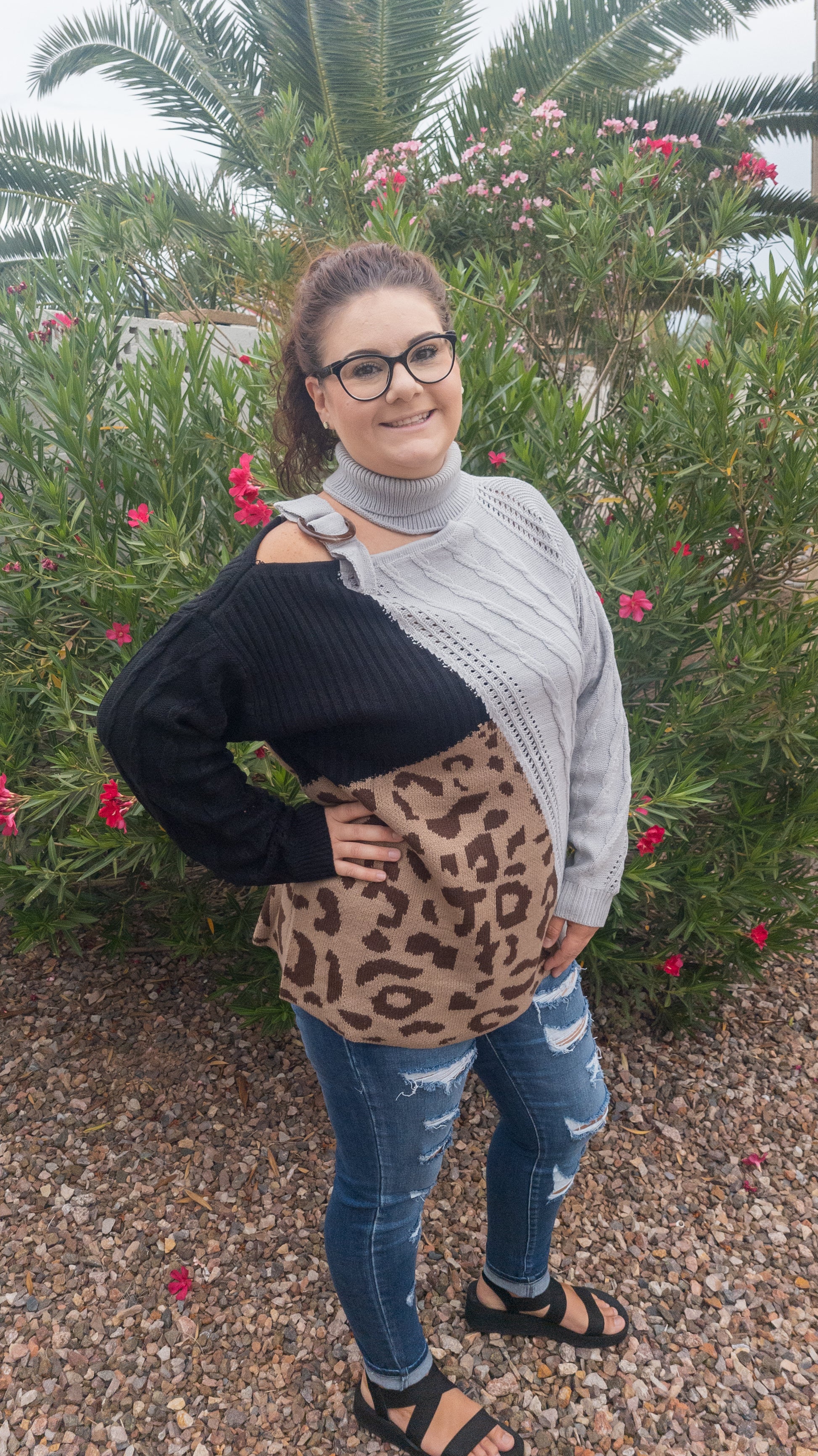 This is a comfy unique block sweater. featuring a gray, black and leopard color block turtleneck with one cut-out shoulder and a non-functioning buckle.  It has an added design on the front that you will not find anywhere else.  You will definitely stand out with this unique sweater.  Wear this with your favorite jeans or skirt.  This would be the perfect sweater for the office, everyday wear, or hanging out with your family and friends. Sizes small through 3XL.