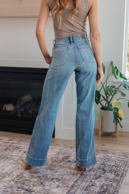 The Mindy Mid Rise Wide Leg Jeans are the perfect closet essential that can be worn year round! Featuring a stretchy light wash denim that shapes a mid rise waist with slanted pockets and zipper fly. Wide cut pant legs end at a wide hem detail and is perfected with lived-in fading throughout.  The acid wash process used to manufacture these amazing jeans may cause a variation in coloring from pair to pair! 0 -24W