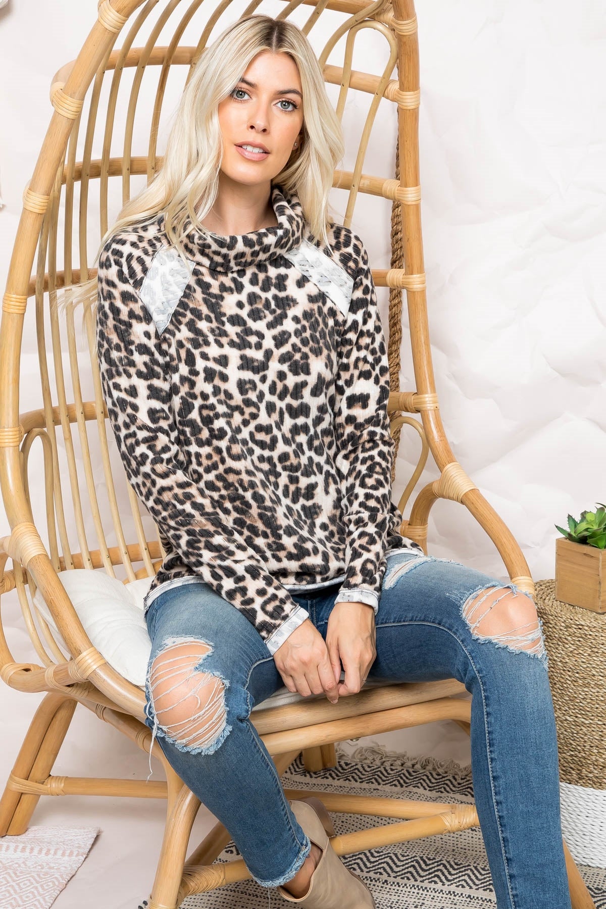 "Walk In The Park" is a thin, buttery soft, leopard print, long sleeve pullover. It features a loose turtle neck and reserve detailing. Sizes small through x-large.