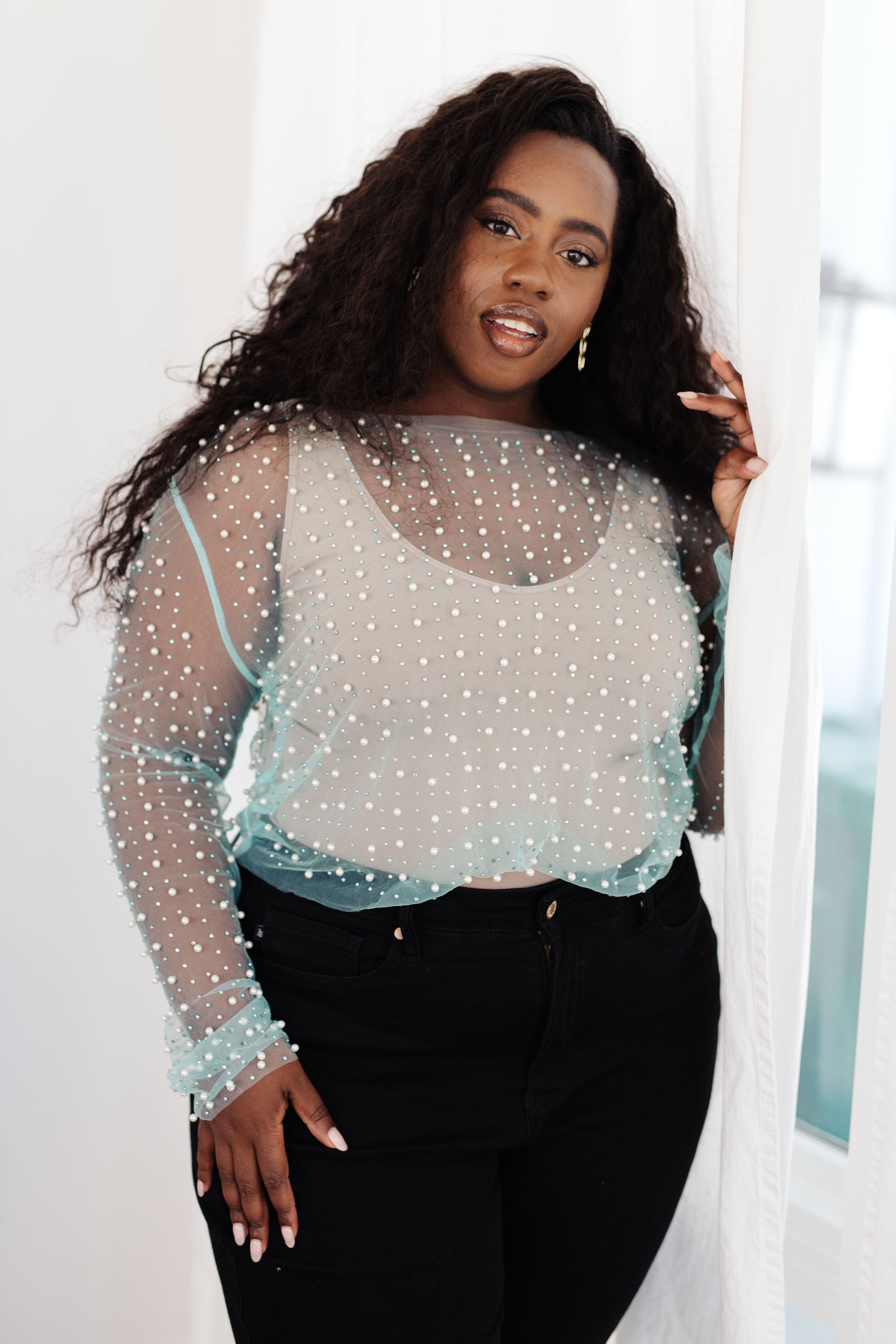 Make waves in the Pearl Diver Layering Top! This mesh long sleeve top is embellished with faux pearls and rhinestones, creating a unique and eye-catching look. Perfect for layering, this on-trend piece will add just the right amount of sparkle and texture to any outfit. Dive deep and stand out! S - 3X