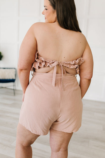Let the Pink Skies Romper take you from day to night in style! This amazing strapless piece has adorable details like the ruffle pleated bust, tie waist, side pockets and shorts! Pair this with heels and a blazer for a daytime look then strip the blazer for date night! S - 3X