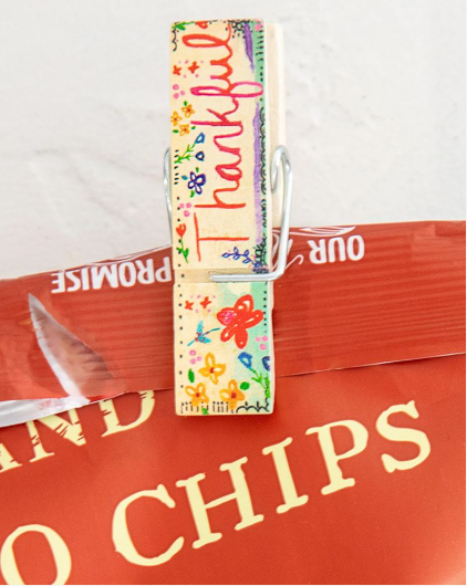 "Grateful"  "Happy"  "Thankful"  "Blessed"  Keep this set of four super-cute Bag Clips from Natural Life handy around the kitchen to help add a bright touch to the room! Use them on open bags to keep food fresh and more. After all, any pantry could use an extra touch of boho flair.  Set of 4 Happy Clips Wood material Each clip measures 2.75"L x 0.75"W x 0.625"H