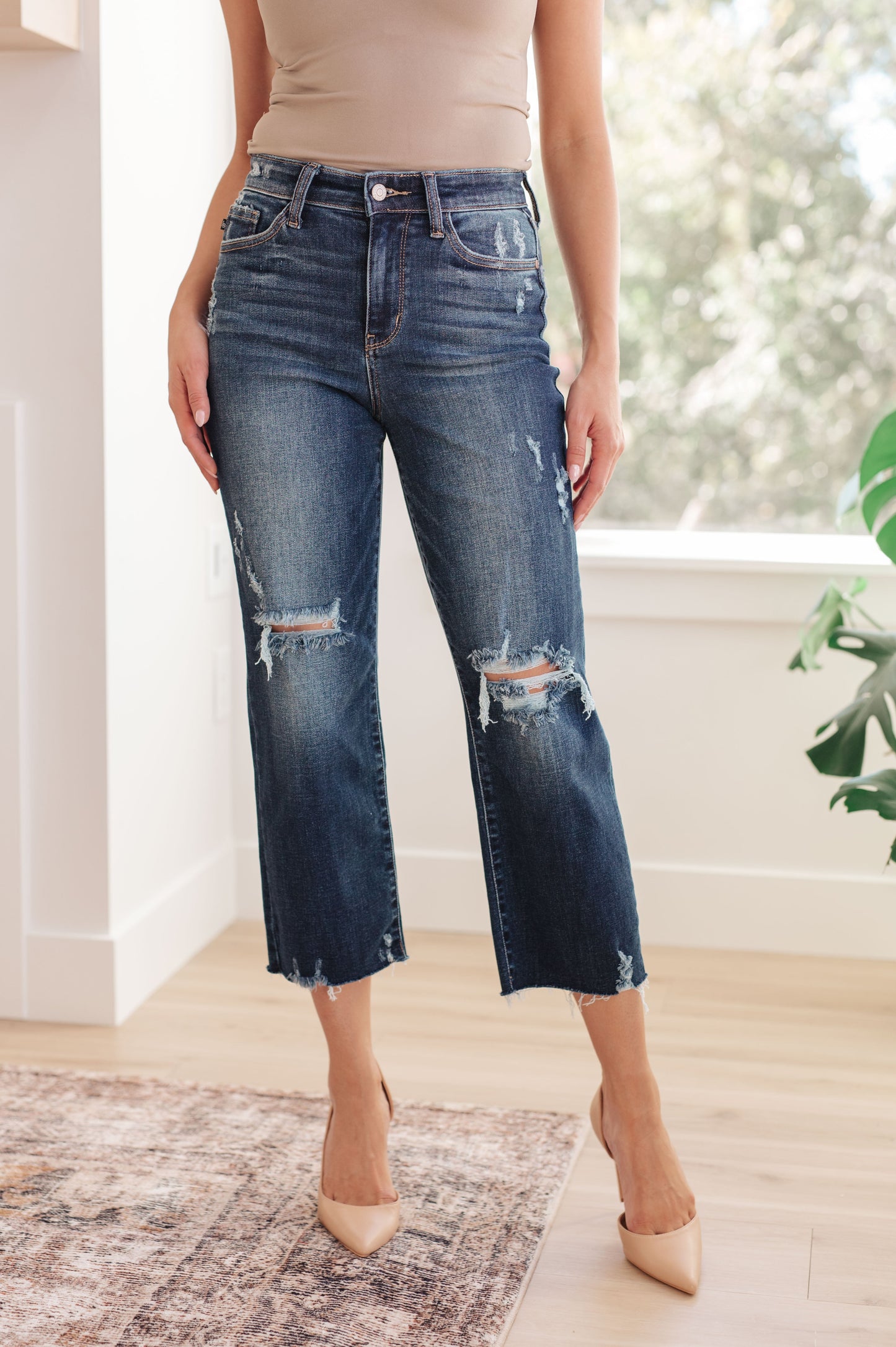 Whitney High Rise Distressed Wide Leg Crop Jeans from Judy Blue. With a high rise fit, dark wash, distressed detailing and raw hem, this jean offers the perfect blend of comfort and chic style. Judy Blue High Rise Zip Fly Dark Wash 4-Way Stretch Distressed Wide Leg Crop 0 - 24W