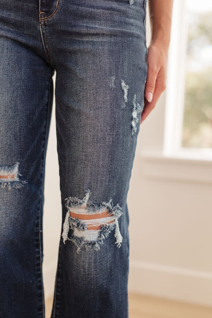 Whitney High Rise Distressed Wide Leg Crop Jeans from Judy Blue. With a high rise fit, dark wash, distressed detailing and raw hem, this jean offers the perfect blend of comfort and chic style. Judy Blue High Rise Zip Fly Dark Wash 4-Way Stretch Distressed Wide Leg Crop 0 - 24W