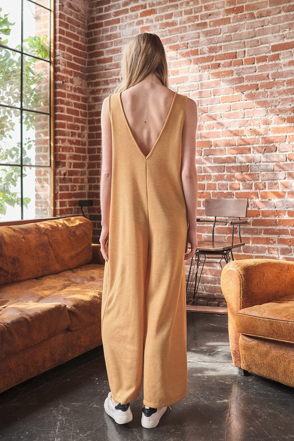The V-Neck Sleeveless Wide Leg Jumpsuit is a chic wardrobe staple. The flattering v-neck design elongates the neckline for a slimming effect. With a sleeveless silhouette and wide leg pants, this jumpsuit offers a modern and sophisticated look.  S - L